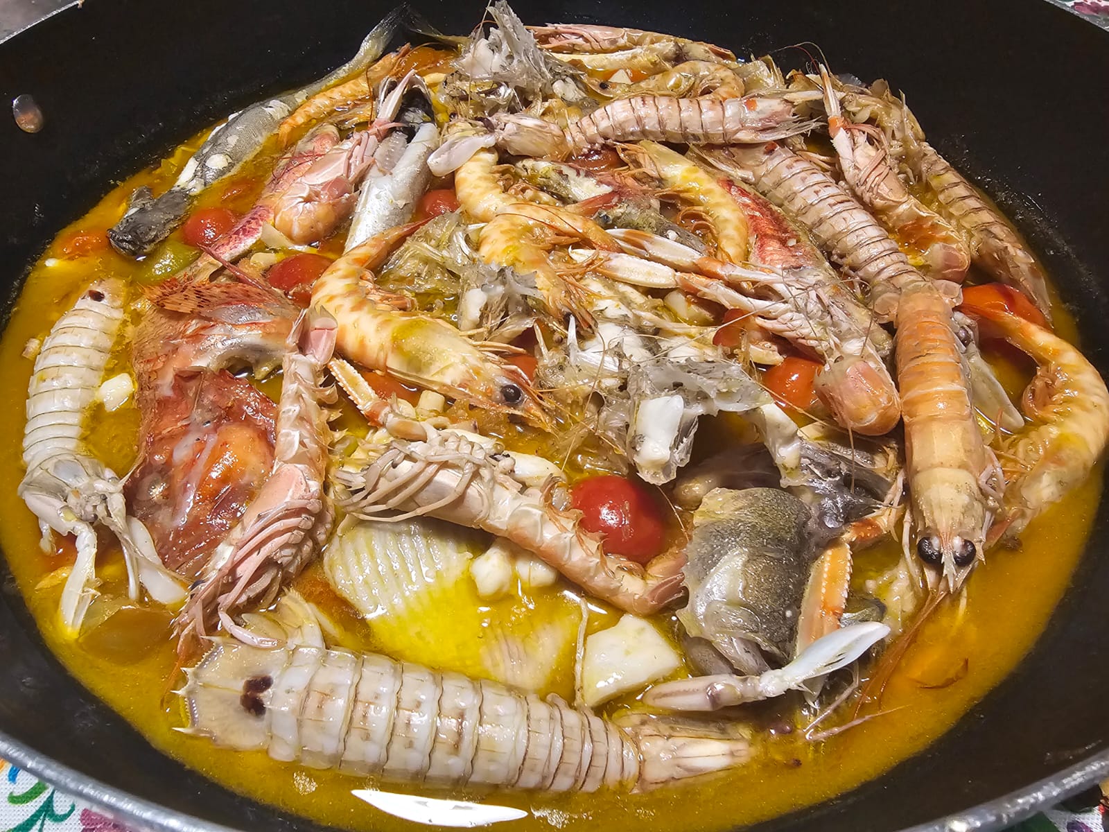 Brodetto alla giuliese fumante nel tegame di alluminio, con scampi e canocchie